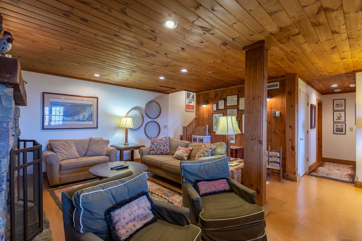 An inviting living area with a fireplace as the focal point, surrounded by a plush sofa, coffee table, and decorative wall art. Lamps provide soft lighting, and the space encourages relaxation, socializing, and unwinding after a day outdoors.